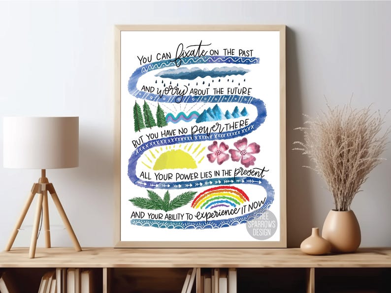 K&ouml;nnte beinhalten: Eine Aquarell-Illustration in Blau-, Gr&uuml;n- und Gelbt&ouml;nen. Die Illustration zeigt einen gewundenen Pfad mit dem Text "Du kannst dich auf die Vergangenheit konzentrieren und dir Sorgen um die Zukunft machen, aber du hast dort keine Macht. All deine Macht liegt in der Gegenwart und deiner F&auml;higkeit, sie zu erleben." Der Text ist in handschriftlicher Form geschrieben. Die Illustration zeigt auch einen Regenbogen, eine Sonne, Wolken und B&auml;ume.