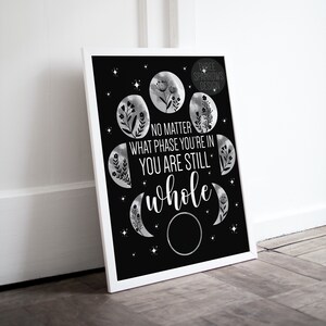 May include: Black and white printable art print with a quote that reads "No matter what phase you're in you are still whole". The quote is surrounded by a circle of moon phases with floral accents.