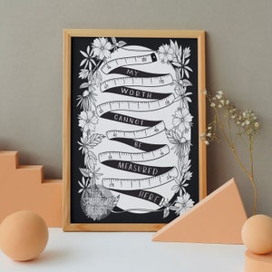 May include: Black and white printable art print with a quote about worth. The quote reads "My worth cannot be measured here." The quote is surrounded by a decorative border of flowers and a measuring tape.