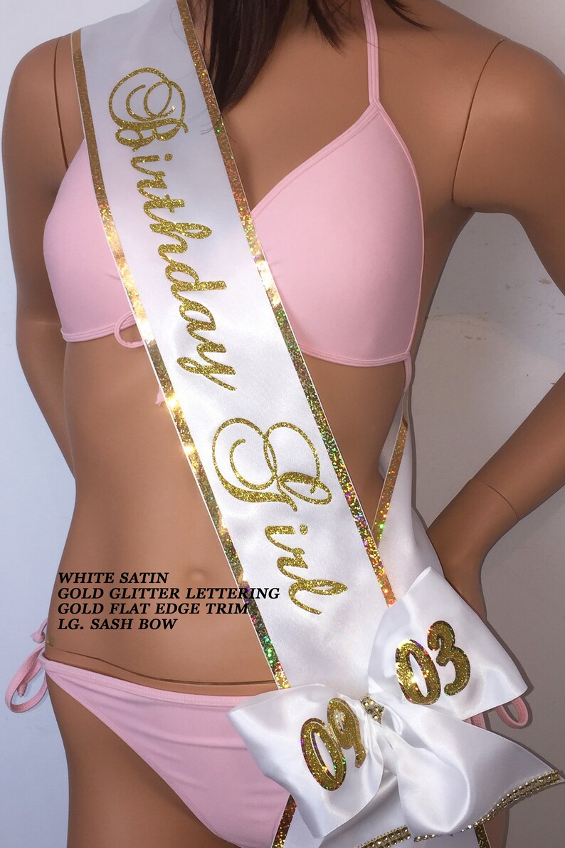Puede incluir: Sash de sat&eacute;n blanco con letras doradas brillantes que dicen "Birthday Girl" y ribete dorado plano. El sash tiene un gran lazo blanco con letras doradas brillantes que dicen "09 03".
