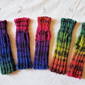 Puede incluir: Cinco pares de guantes sin dedos de punto de colores vivos con detalles negros. Los guantes están dispuestos en fila de izquierda a derecha, numerados del 1 al 5.