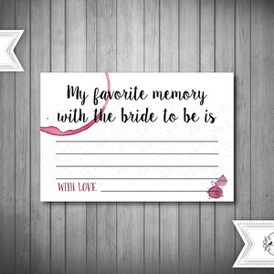 May include: White card with black text that reads "My favourite memory with the bride to be is" with a blank space for writing. The card has a red wine stain and the words "With Love" at the bottom.