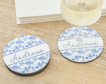 May include: Two blue and white ceramic coasters with the name "Andrews" written in black script on each. The coasters are on a wooden tray with a glass of white wine.