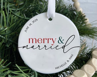 May include: White ceramic ornament with the words "merry & married" in red, green, and black script. The date "June 14, 2024" and names "Michelle & Max" are also printed on the ornament. A white ribbon is attached for hanging.