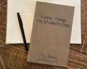 May include: A brown leather-bound journal with the title "Funny Things My Students Say" and the text "Mrs. Thomas Savannah Elementary" on the front cover.