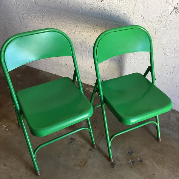 A pair of vintage industrial metal foldings chairs
