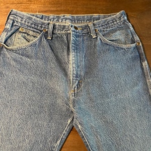 May include: A pair of blue denim jeans with a classic five-pocket style. The jeans have a straight leg and a relaxed fit.