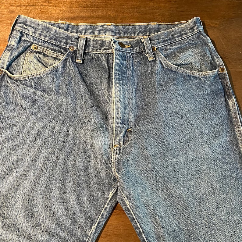 May include: A pair of blue denim jeans with a classic five-pocket style. The jeans have a straight leg and a relaxed fit.
