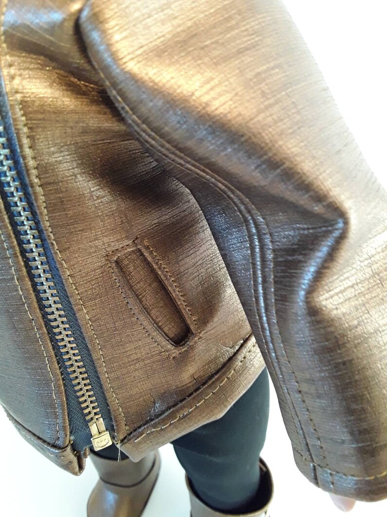 May include: A brown leather jacket with a zipper closure and a small pocket on the sleeve.