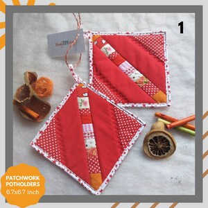 Peut inclure: Deux maniques de cuisine en patchwork rouge avec des étoiles blanches et des accents orange. Les maniques mesurent 6,7 x 6,7 pouces.