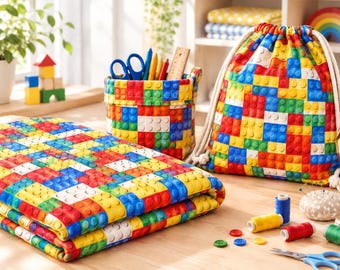 May include: A fabric set featuring a repeating pattern of red, blue, yellow, and white interlocking building blocks. The set includes a folded rectangular fabric piece, a cylindrical storage basket, and a drawstring backpack with white rope cords.
