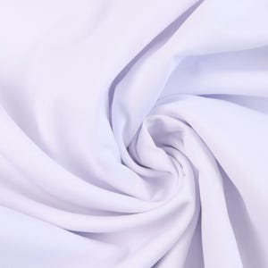 Pode incluir: Um close-up de tecido branco, artisticamente disposto em um padrão de redemoinho. O tecido parece liso e possivelmente leve, com sombras suaves criando profundidade e textura. A impressão geral é de elegância e simplicidade.