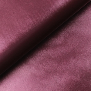 Peut inclure: Gros plan sur un tissu plié de couleur bordeaux foncé. La matière présente une texture lisse et légèrement brillante, avec des plis et des ombres subtils ajoutant de la profondeur. Le tissu semble être une matière luxueuse, peut-être du satin ou du velours.