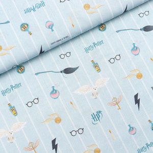 Puede incluir: Tela a rayas azules y blancas con un patrón repetido de ilustraciones con temática de Harry Potter. Las ilustraciones incluyen gafas, una escoba, una botella de poción, una snitch dorada, un rayo, un búho y las palabras "Harry Potter".