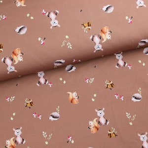 Könnte beinhalten: Brauner Stoff mit einem sich wiederholenden Muster aus Eichhörnchen, Igeln, Pilzen und Blättern. Der Stoff hat eine dezente Textur.