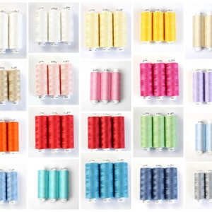 Pode incluir: Uma coleção de 12 carretéis de fio em várias cores, incluindo branco, bege, amarelo, rosa, lavanda, laranja, vermelho, verde, azul claro, turquesa, azul e cinza. Cada carretel contém 3 fios individuais.