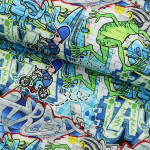 Può includere: Un muro di mattoni bianchi con graffiti blu, verdi e gialli. I graffiti includono le parole "TRASH" e "HAVE", oltre a una rana verde e due persone che vanno in bicicletta.