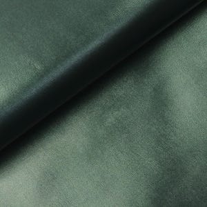 Könnte beinhalten: Nahaufnahme eines glatten, dunkelgrünen Stoffes. Der Stoff hat einen dezenten Glanz und ein weiches, luxuriöses Gefühl.