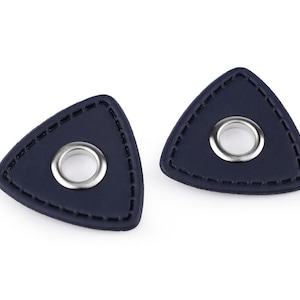 Könnte beinhalten: Zwei dunkelblaue Leder-Plektronen mit einem silbernen Metallring in der Mitte.