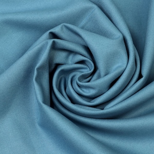 Könnte beinhalten: Nahaufnahme eines wirbelförmig angeordneten, teal-farbenen Stoffes. Das Material hat eine feine Textur und ist eng gefaltet, wodurch ein spiralförmiges Muster entsteht. Die Farbe ist ein gedämpftes Blaugrün mit weichen Schatten und Glanzlichtern.