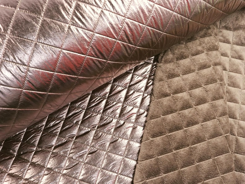 May include: Two pieces of quilted fabric, one in a metallic rose gold color and the other in a brown color. Both fabrics have a diamond-shaped quilting pattern.