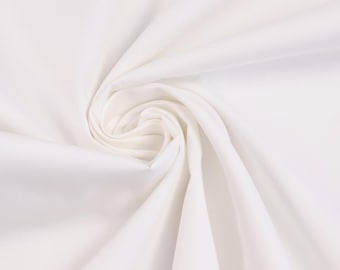 May include: A solid white fabric with a smooth texture, arranged in a central spiral swirl pattern. The material features soft, flowing folds that radiate outward from the center, creating subtle shadows and highlights across the surface.