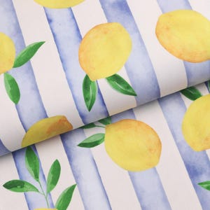 Op de afbeelding: Stof met een aquarelontwerp van gele citroenen en groene bladeren tegen een achtergrond van blauwe en witte verticale strepen. De citroenen zijn verspreid over de stof, waardoor een fris, zomers patroon ontstaat.