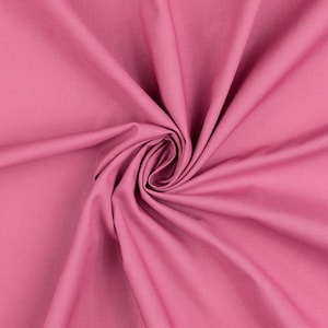 Könnte beinhalten: Nahaufnahme eines Wirbels aus rosa Stoff. Der Stoff hat eine einfarbige Farbe mit sichtbarer Textur und Falten. Die Mitte des Wirbels ist eng zusammengezogen und bildet einen Brennpunkt. Der Stoff scheint Baumwolle oder ein ähnliches Material zu sein.