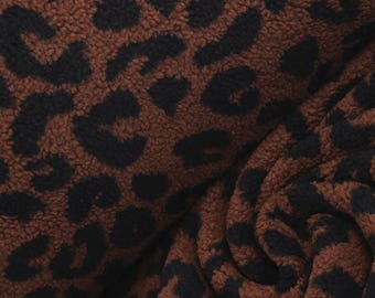 May include: A plush, textured fabric featuring a brown and black leopard print pattern. The material has a thick, fuzzy surface with deep folds and ripples, showcasing the repeating animal spot design across the soft, dense textile texture.