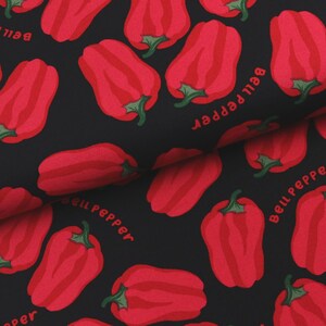 Op de afbeelding: Zwarte stof met een herhaald patroon van rode paprika's en de tekst "Bell pepper" in het rood. De paprika's hebben groene stelen en zijn gearceerd om een 3D-effect te geven.