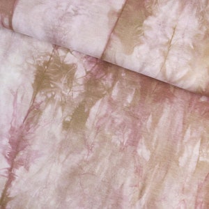 Könnte beinhalten: Ein Nahaufnahme eines weichen, rosa und braunen Batik-Stoffes. Der Stoff hat einen dezenten, verblassten Look mit Schattierungen von Rosa, Braun und Weiß.