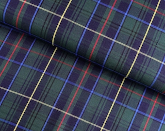 May include: Close-up of a folded fabric with a classic plaid pattern. The fabric features a dark green base with intersecting lines in navy blue, red, yellow, and blue, creating a traditional tartan design. The fabric has a slight sheen.
