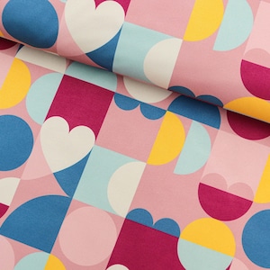Könnte beinhalten: Rosafarbener Stoff mit einem geometrischen Muster aus weißen, gelben, blauen und burgunderfarbenen Kreisen, Halbkreisen und Herzen.