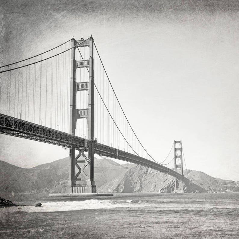 May include: A black and white photograph of the Golden Gate Bridge in San Francisco, California. The bridge is a suspension bridge with two towers and a long span.