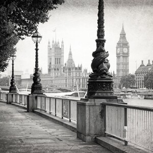 Op de afbeelding: Een zwart-witfoto van een trottoir langs de Theems in Londen, Engeland. De Houses of Parliament en Big Ben zijn op de achtergrond te zien.