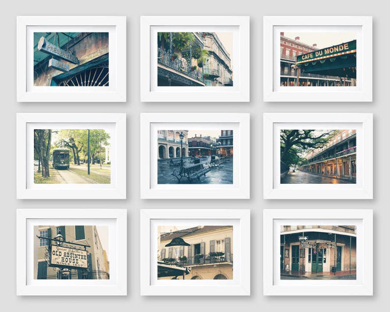 May include: Nine framed photographs of New Orleans, Louisiana. Each photo features a different street scene, including a streetcar, a cafe, and a building with a sign that reads "Old Absinthe House".