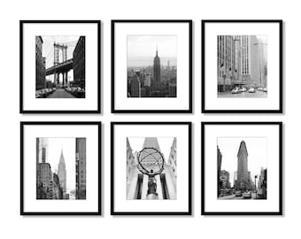 Puede incluir: Seis fotografías en blanco y negro enmarcadas de los monumentos de la ciudad de Nueva York. Las imágenes incluyen el puente de Manhattan, el Empire State Building y el edificio Chrysler. Cada fotografía está en un marco negro con un passe-partout blanco.