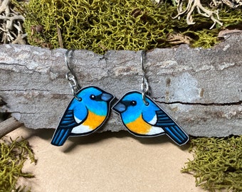 May include: A pair of bluebird earrings with silver hooks. The birds are painted with blue, white, orange, and black details.