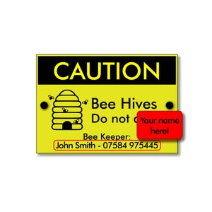 May include: A yellow caution sign with black text that reads "CAUTION Bee Hives Do not" and a red box that reads "Your name here!"  The sign also has a black and white illustration of a beehive with bees flying around it.  The bottom of the sign reads "Bee Keeper: John Smith - 07584 975445".
