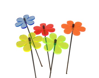 May include: Five colorful acrylic flowers on black metal stems. The flowers are in shades of blue, red, yellow, and green.