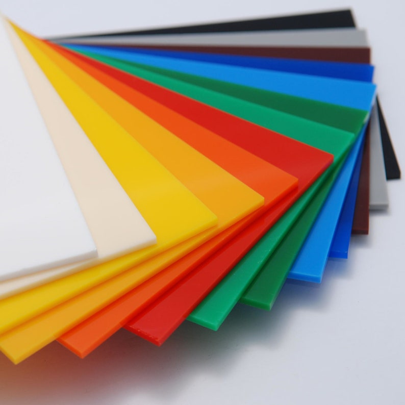 May include: A fan-shaped arrangement of colorful plastic sheets, ranging from white to black, with a rainbow of colors in between.