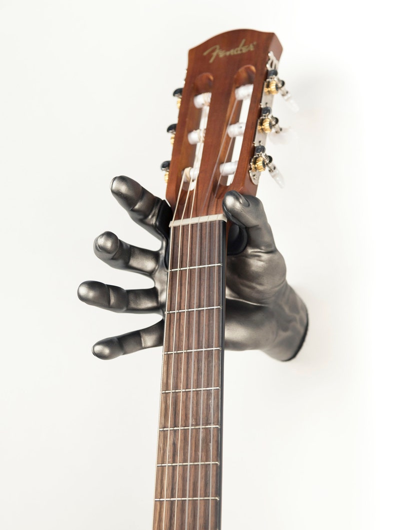 Classic Grip hand guitar hanger from GuitarGrip. Silver Antique Finish. Right Hand holding Classical Guitar.