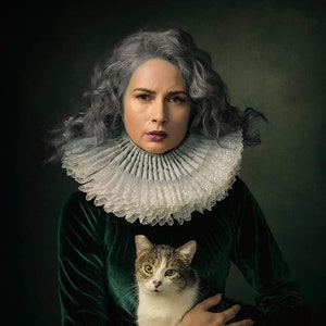 May include: A woman with silver hair wears a white lace ruff and a dark green velvet dress. She holds a tabby cat in her arms.