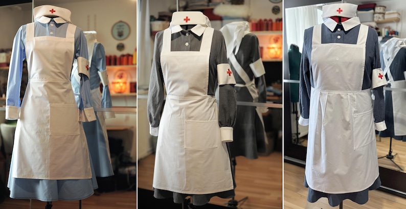 Puede incluir: Tres maniqu&iacute;es visten diferentes variaciones de un uniforme de enfermera blanco. Cada uniforme presenta un delantal blanco con una sola cruz roja en el lado izquierdo del pecho. Los uniformes son todos de diferentes tonos de azul.