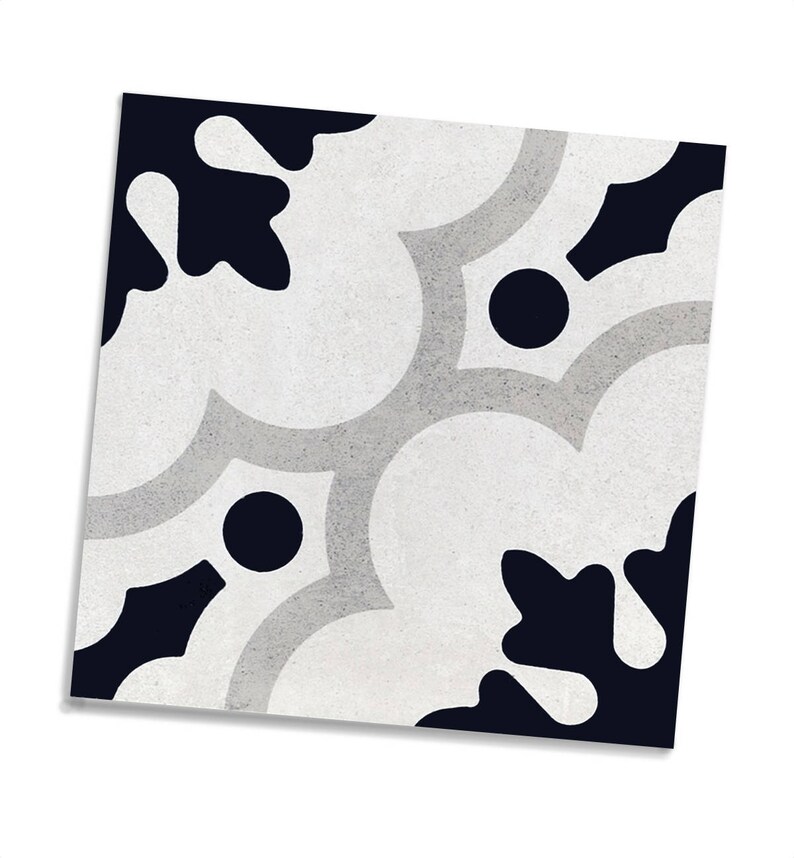 May include: Square decorative tile with a repeating pattern. The design features a combination of white, light grey, and navy blue shapes, including floral-like forms and circular accents. The tile has a textured appearance.