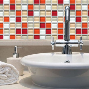 May include: A bathroom interior with a white sink, chrome tap, and a decorative tile backsplash. The mosaic tile features red, orange, beige, and white squares. A rolled white towel and soap dispenser are also present.