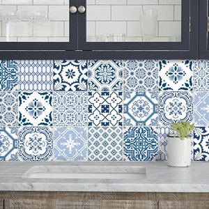 Puede incluir: Azulejos decorativos de cerámica en tonos azules y blancos, dispuestos en un patrón de cuadrícula. Los azulejos presentan varios diseños florales y geométricos. Los azulejos están instalados como salpicadero en una cocina.