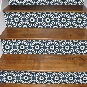 May include: Wooden staircase with risers featuring a repeating geometric pattern in navy blue and white. The steps are a warm brown colour, contrasting with the patterned risers. The design adds a decorative element to the staircase.