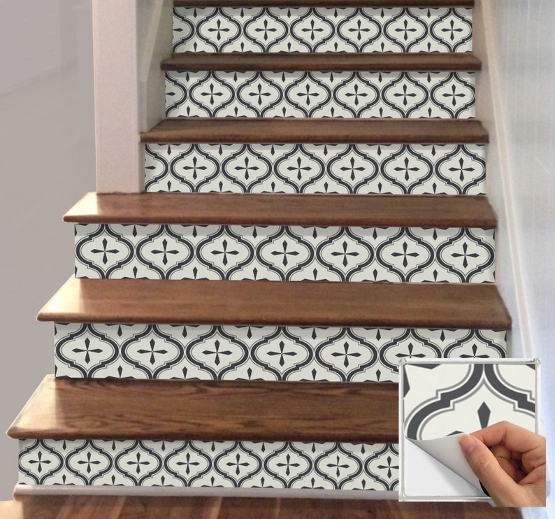 May include: Staircase with wooden steps and decorative tile risers. The tile features a black and cream quatrefoil pattern. A sample tile with a peeling corner is shown in the lower right corner.
