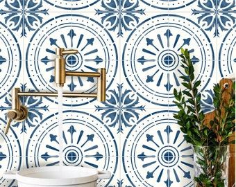 May include: A kitchen setting with a white pot on a black hob, and water pouring from a brass tap. The wall is tiled with a blue and white floral pattern. A glass vase with green sprigs and a wooden chopping board are on the right.